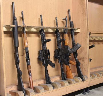 gun rack holding assorted rifles and semi-automatic weapons