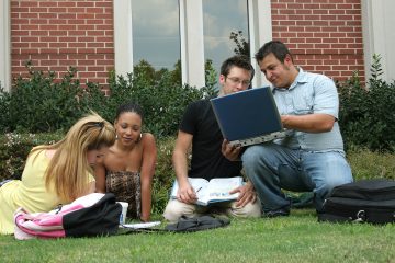 College students on campus. Study session in the grass.
