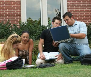 College students on campus. Study session in the grass.