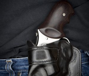 Stainless Steel .357 revolver in a black leather holster on a man's side.